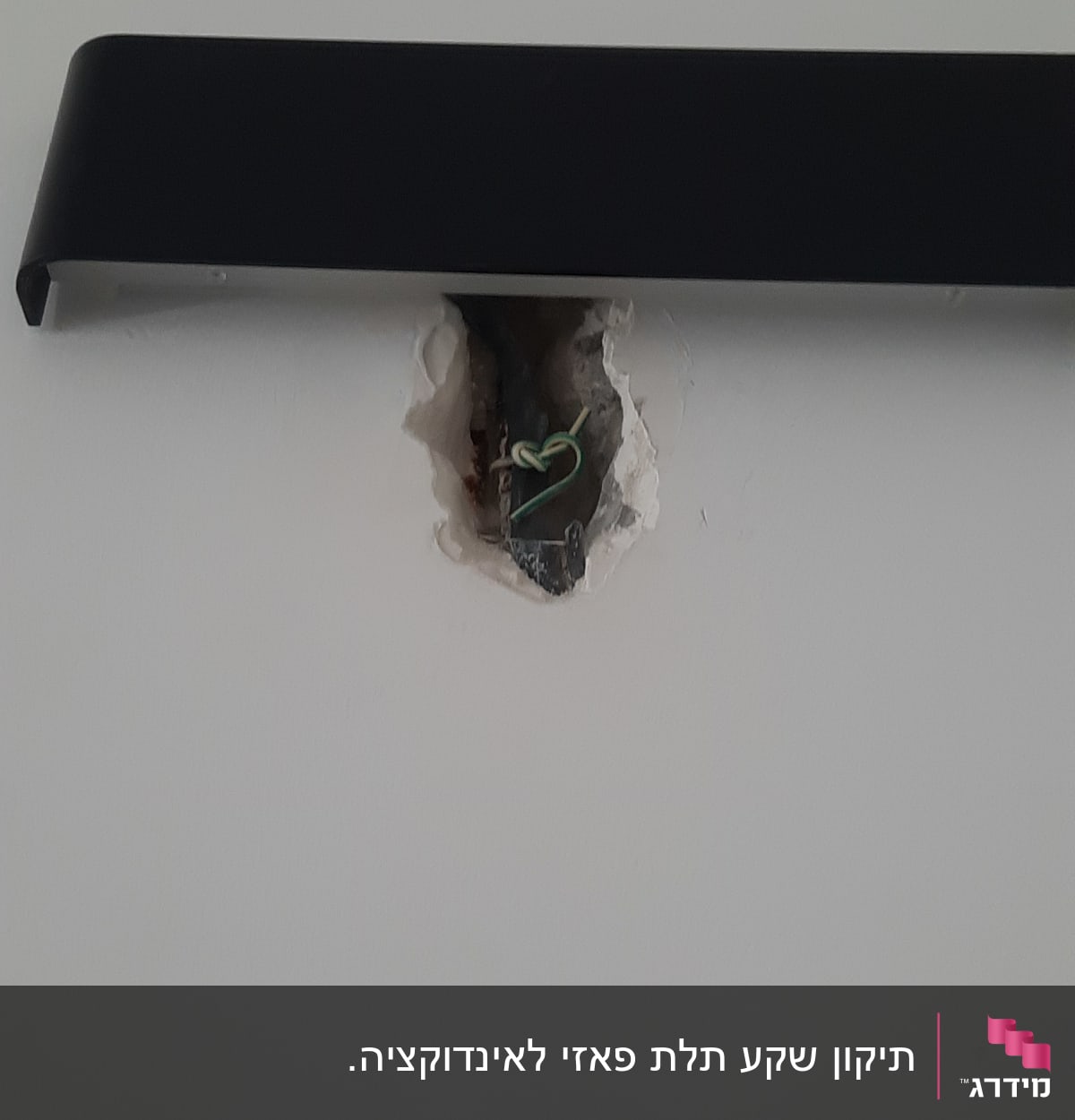 חוטי חשמל יוצאים מקיר עם חור